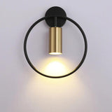 Black ring paired with a gold cylinder spot on a pale wall