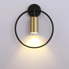 Black ring paired with a gold cylinder spot on a pale wall