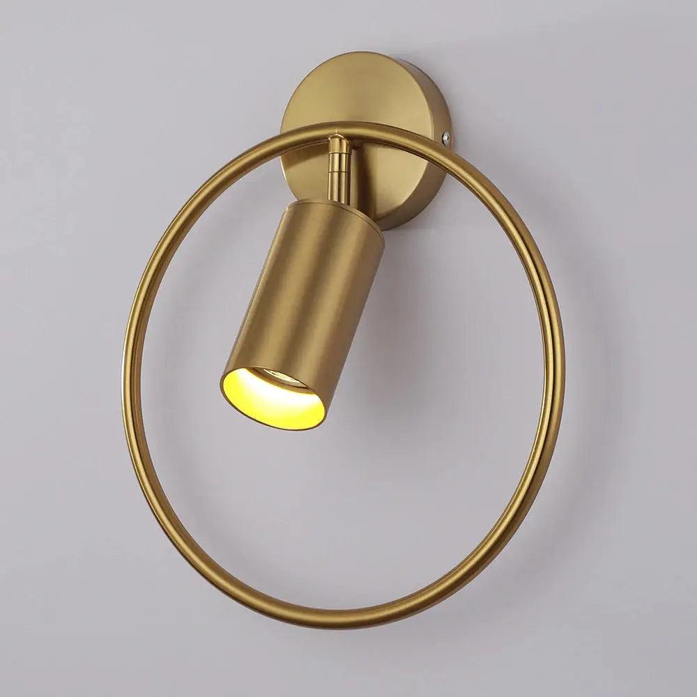 Brass cylinder tilted within its gold ring against a pale wall