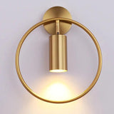 Gold sconce with the ring set behind a wide brass cylinder