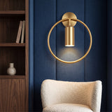 Gold ring wall sconce with a downward cylinder spot on navy panelling