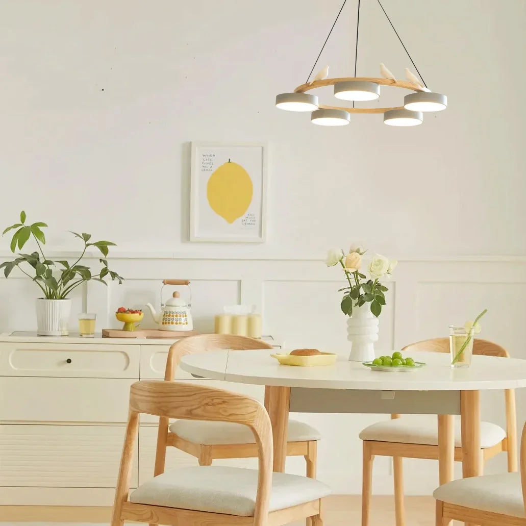 Integrated LED drum shades glowing warmly on the modern round wood chandelier