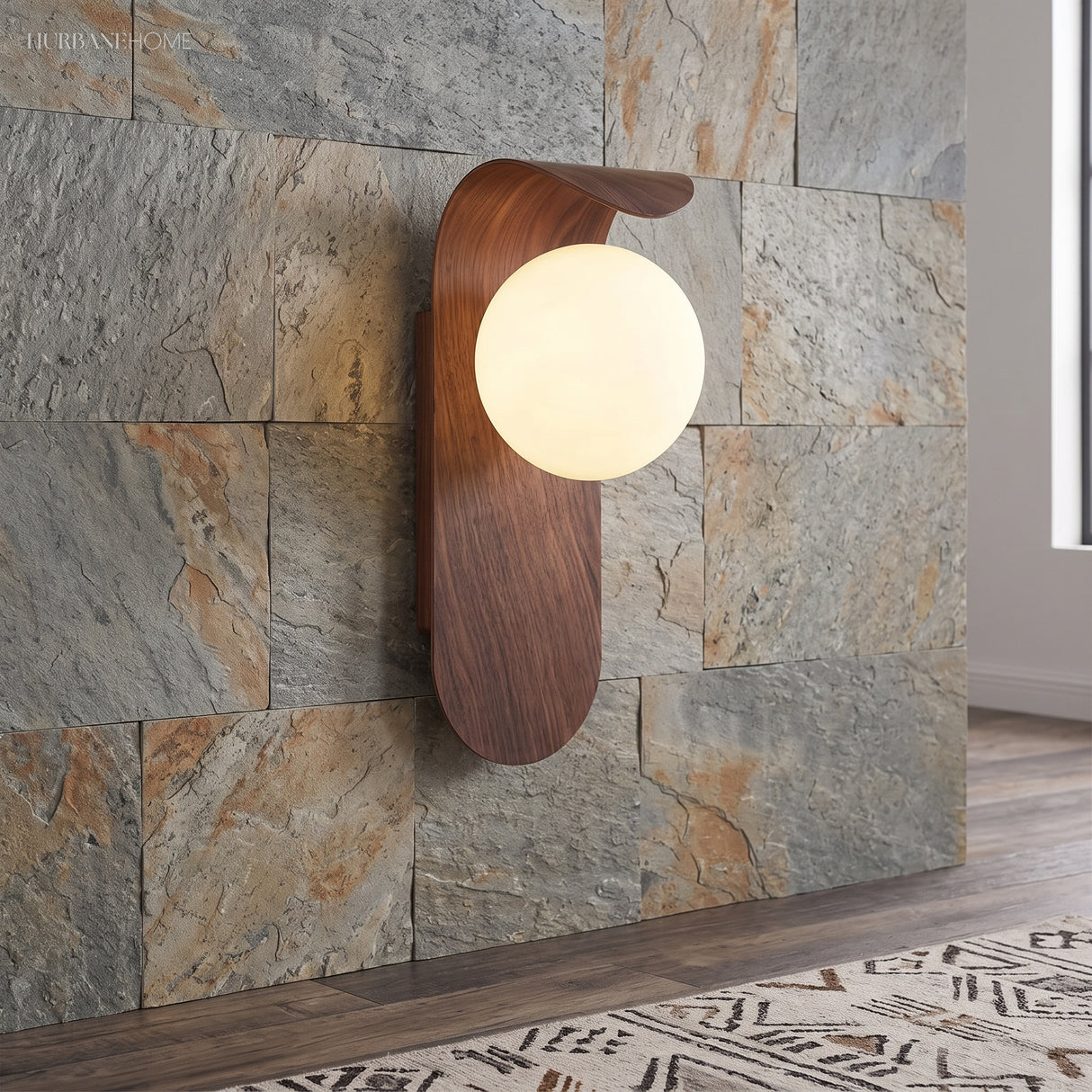 Wood tone wall sconce lit against a stone feature wall in hallway