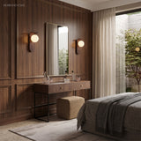Pair of modern wall sconces flanking a mirror in a bedroom dressing area