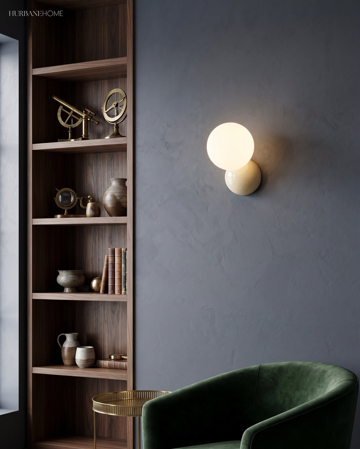 Wall sconce lit against a deep blue wall next to tall shelving and a velvet chair