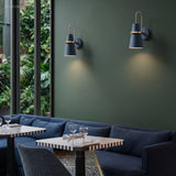 Two blue cone sconces above banquette seating and a dark table