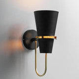 Black cone sconce lit warm and seen from a low angle