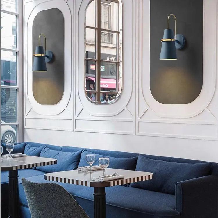 Blue cone sconces on mirrored panels above a bar banquette