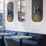 Blue cone sconces on mirrored panels above a bar banquette