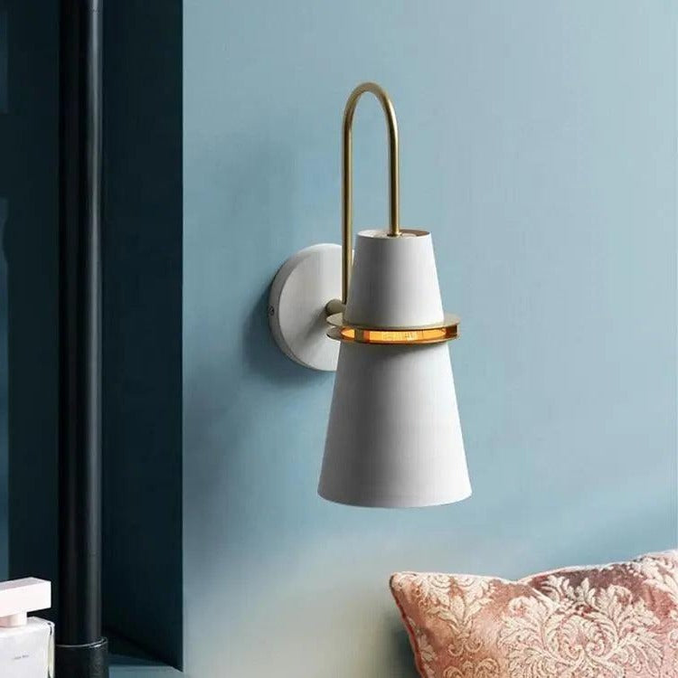 White cone sconce lit on a teal wall beside a dark panel