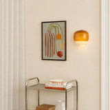 Modern wall sconce with tinted glass shade shown in room context