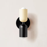 Cream and black cylinders mounted on a black round backplate