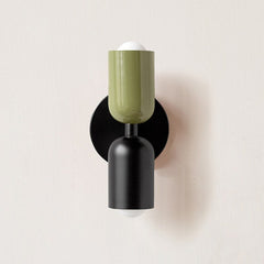 Olive and black cylinders mounted on a black round backplate