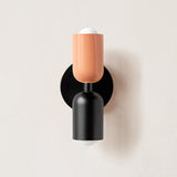 Terracotta and black cylinders on a black round backplate