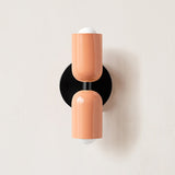 Terracotta and cream cylinders on a black round backplate