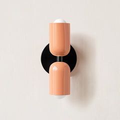 Terracotta and cream cylinders on a black round backplate