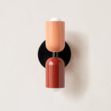 Terracotta and dark red cylinders shown on a black backplate