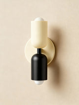 Cream and black cylinders on a cream backplate against beige
