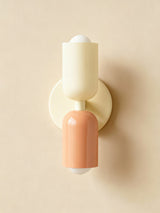 Cream top and terracotta base cylinders on a cream backplate