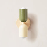 Olive and cream cylinders mounted on a cream round backplate