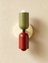 Olive and dark red cylinders on a cream backplate seen straight on