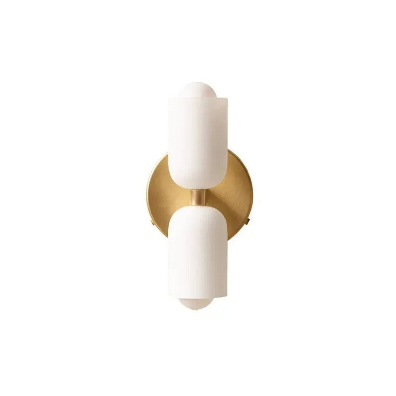 Two white cylinders on a gold backplate without a cord
