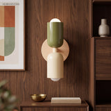 Olive and cream sconce lit on walnut panelling above a sideboard
