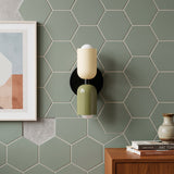 Cream and olive cylinder sconce on green hexagon tiled wall
