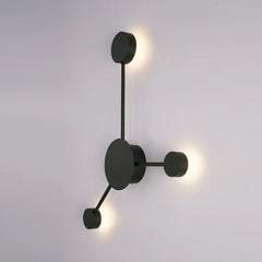 Black three head wall sconce lit against a plain grey background
