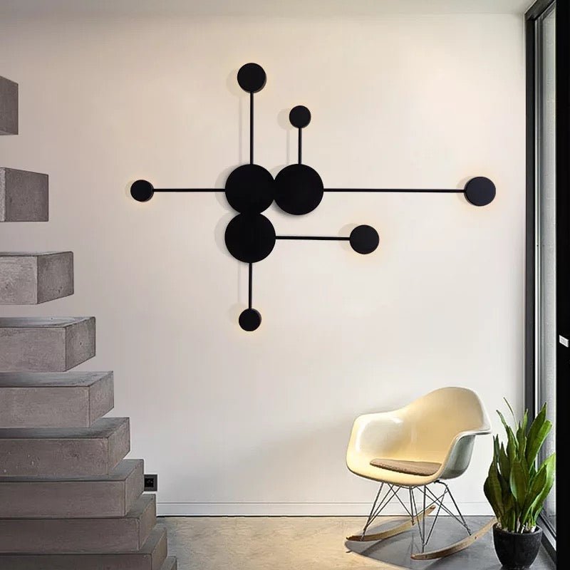 Black six head wall sconce lit on a concrete stairwell wall