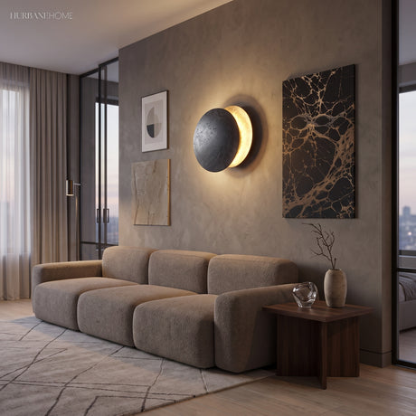 Moon eclipse sconce glowing against a deep blue textured wall