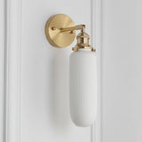 Slim capsule white shade on a rigid brass arm and round backplate