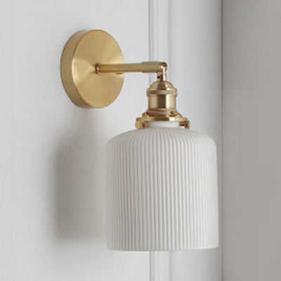 Ribbed drum white shade on a brass arm shown against white panelling