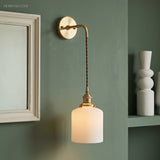 Ribbed drum shade hanging on a braided cord beside a picture frame
