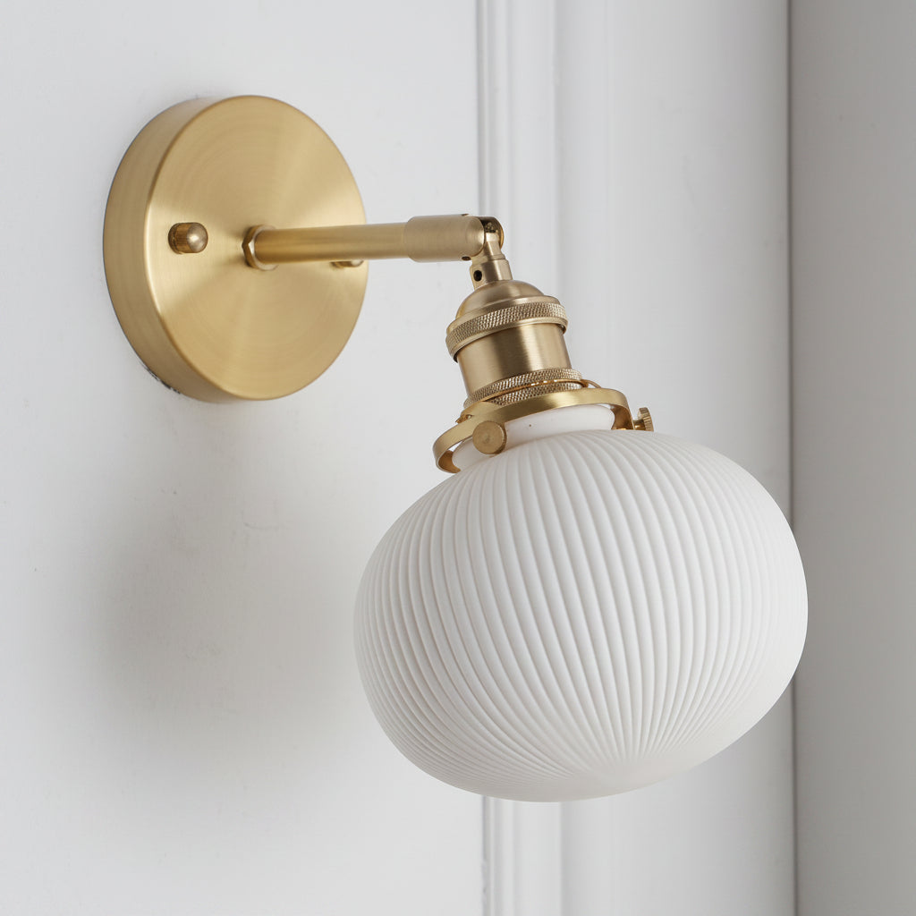 Wide ribbed white shade on a brass arm shown on panelled white