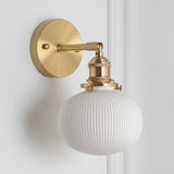Wide ribbed white shade on a brass arm seen from the side