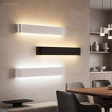 Three linear wall sconces in silver black and white on a wall