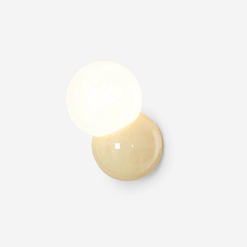 Studio view of the wall sconce with a butter yellow backplate and lit opal globe