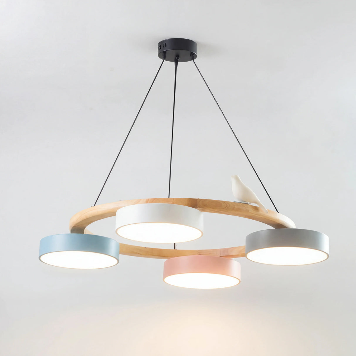 Full colourful wood bird chandelier with five macaron drum shades on a white background