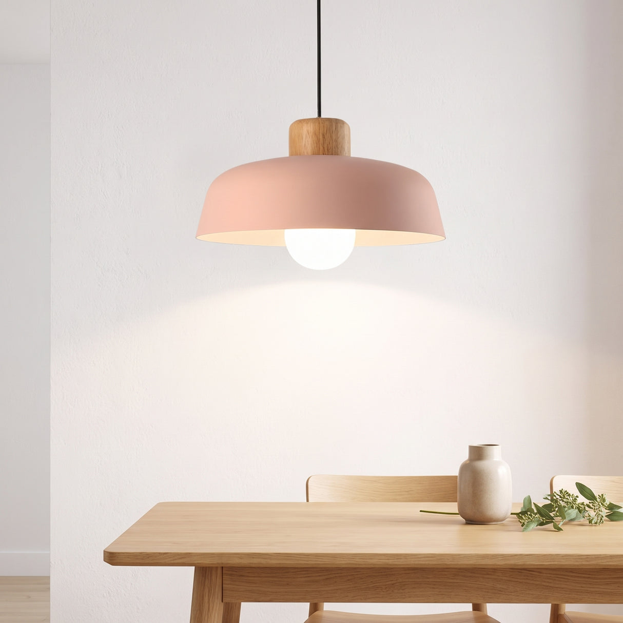 Pink dome pendant with a wood collar above a pale oak dining table