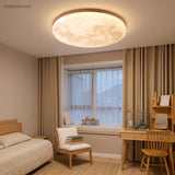 Warm-lit moon ceiling light above an oak bedroom with a reading chair