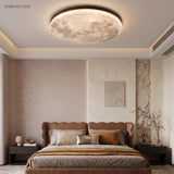 Walnut-rim moon ceiling light over a leather bed and stone-textured wall