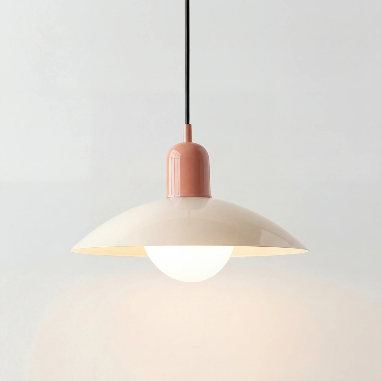 Modern glass globe pendant light shown in beige with a metal dome shade