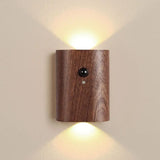Dark wood sensor wall light lit on a plain cream wall