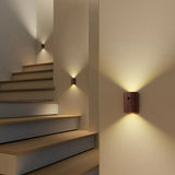 Two wood sensor lights lit beside a timber staircase