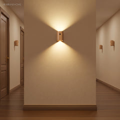 Wood sensor wall light lit on a plain wall in a hallway
