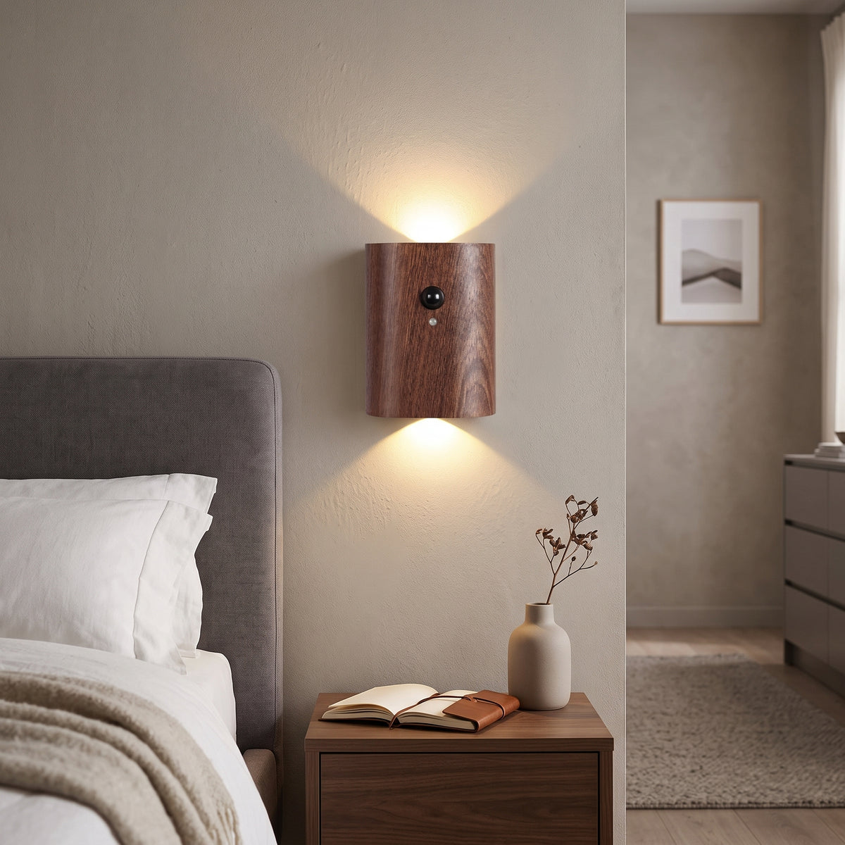 Dark wood motion sensor wall light lit beside a bed and nightstand