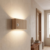 Wood-grain motion sensor wall light glowing up and down a hallway wall