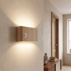 Wood-grain motion sensor wall light glowing up and down a hallway wall