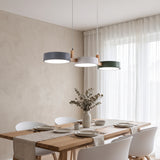 Multi light pendant on a wood bar over a set oak table by sheer curtains